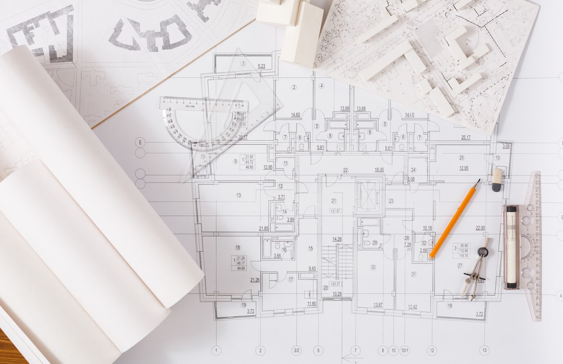 Un plano de una casa con un lápiz, una regla y una maqueta.