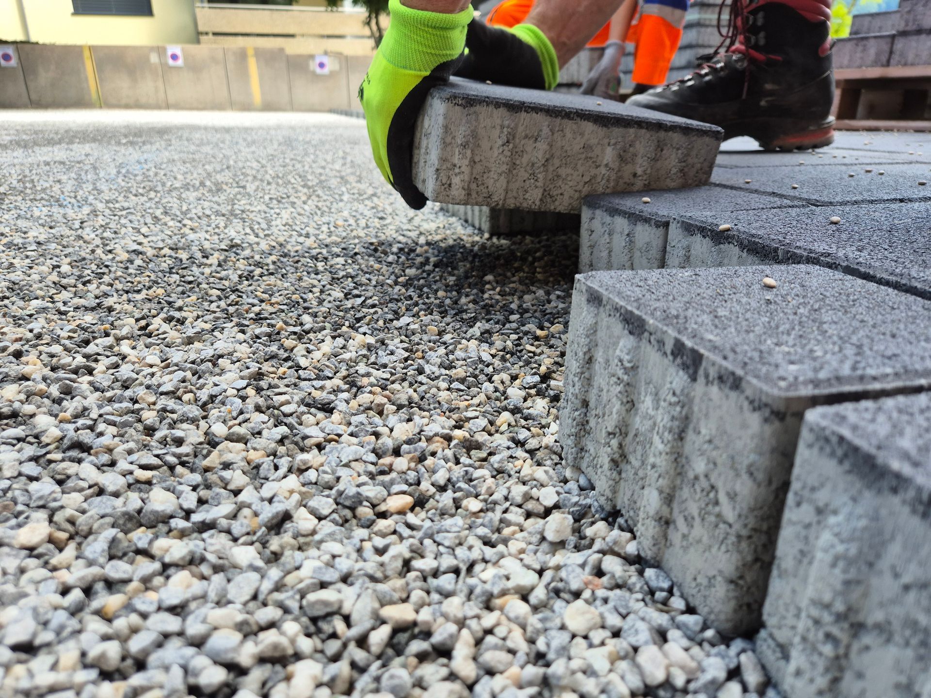 Ein Kopfsteinpflasterweg schlängelt sich durch eine grüne Rasenfläche in Richtung einer roten Scheune.