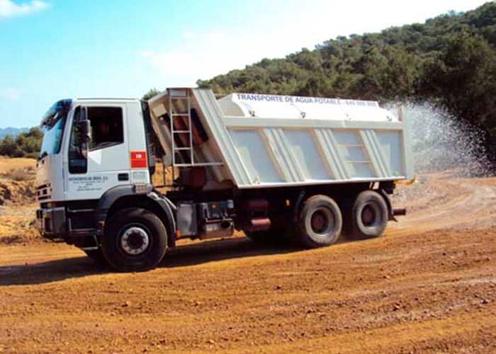 Un camión volquete circula por un camino de tierra
