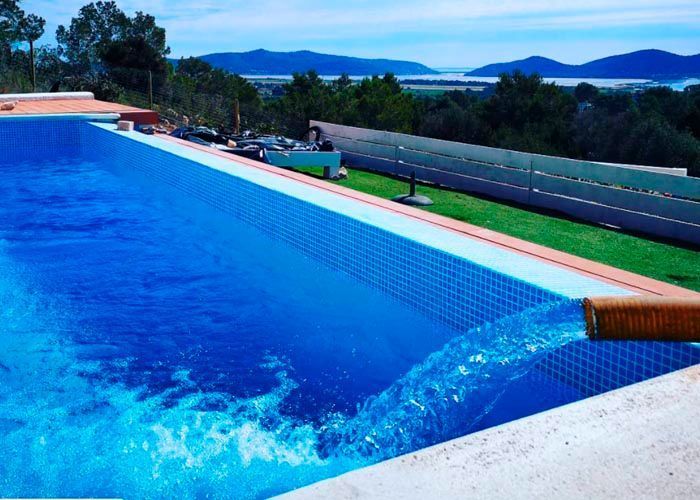 Una gran piscina con montañas al fondo.