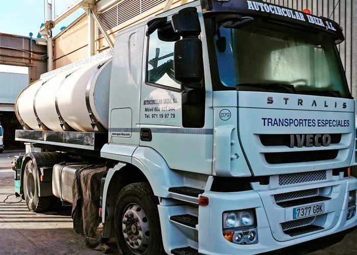 Un camión Iveco blanco está estacionado frente a un edificio.