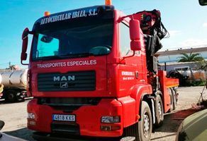 Un camión de hombre rojo está estacionado en un estacionamiento.