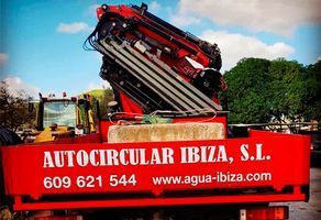 Un camión rojo con una grúa encima que dice autocircular ibiza sl