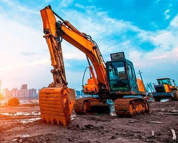Una excavadora amarilla está trabajando en un sitio de construcción.
