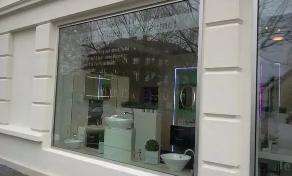 Schaufenster mit Warenpräsentation und Spiegelungen auf einer Stadtstraße