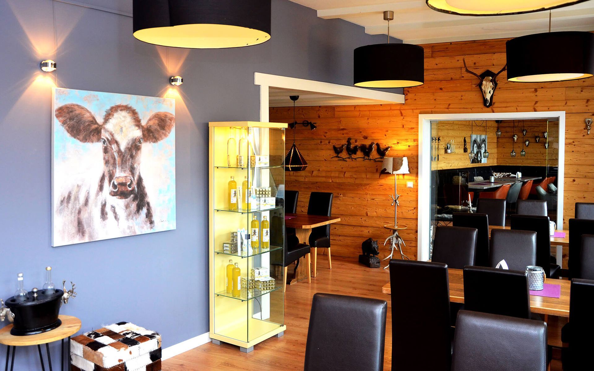 Ein Esszimmer mit einem Gemälde einer Kuh an der Wand