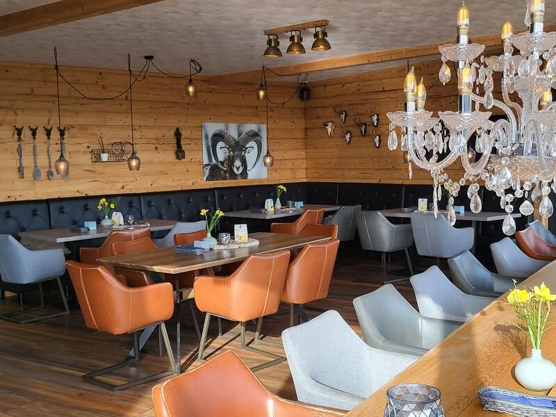 Ein Restaurant mit Tischen und Stühlen und einem Kronleuchter.
