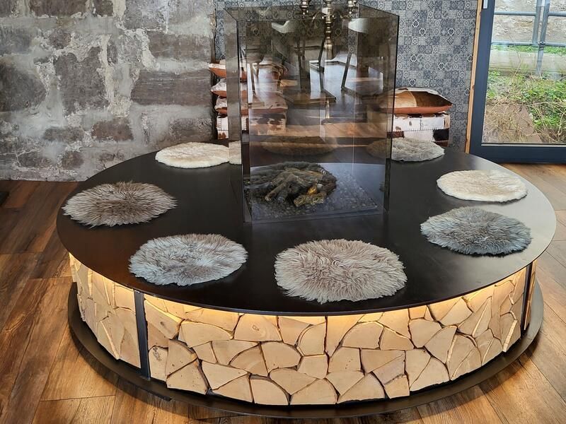 Ein runder Tisch mit einem Kamin im Hintergrund