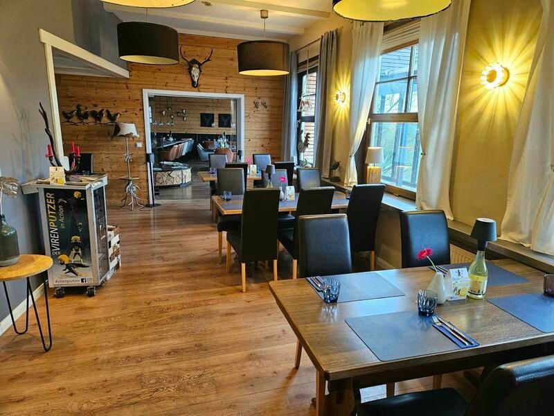 Ein Esszimmer mit Tischen und Stühlen und einem großen Fenster.