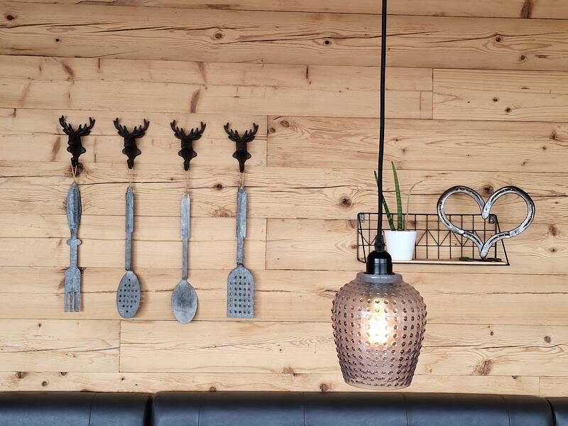 Eine Holzwand mit Haken und einer daran hängenden Lampe