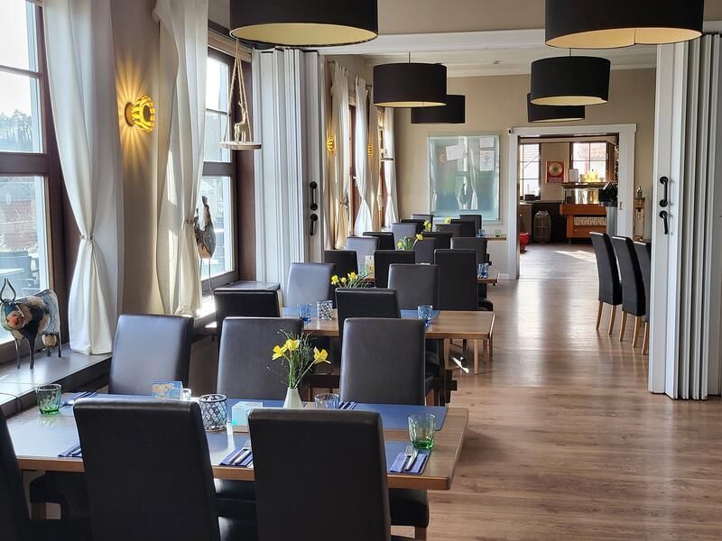 Ein Restaurant mit Tischen und Stühlen und vielen Fenstern