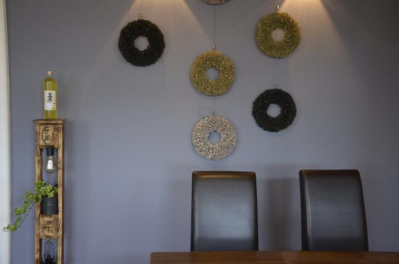 Ein Esszimmer mit Tisch und Stühlen und Kränzen an der Wand.