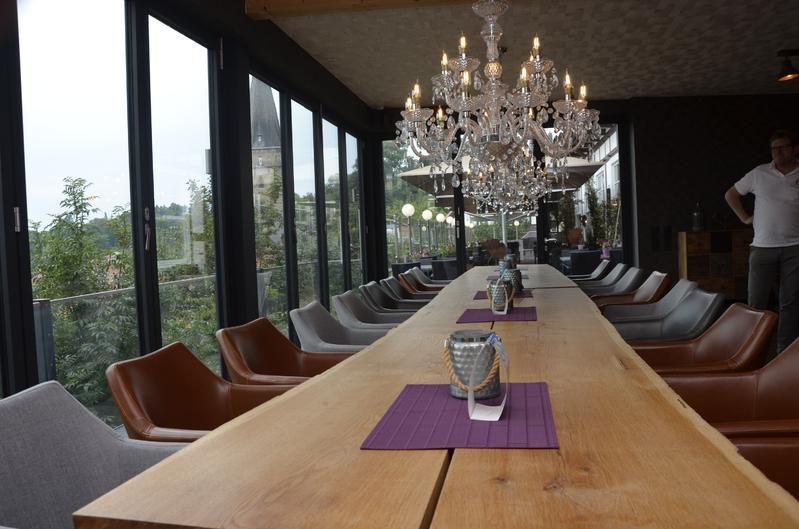 Ein langer Holztisch mit einem Kronleuchter, der von der Decke hängt