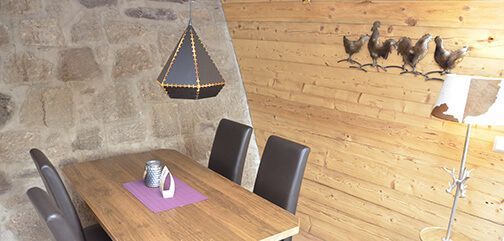 Ein Esszimmer mit einem Holztisch und Stühlen und einem Boot an der Wand.