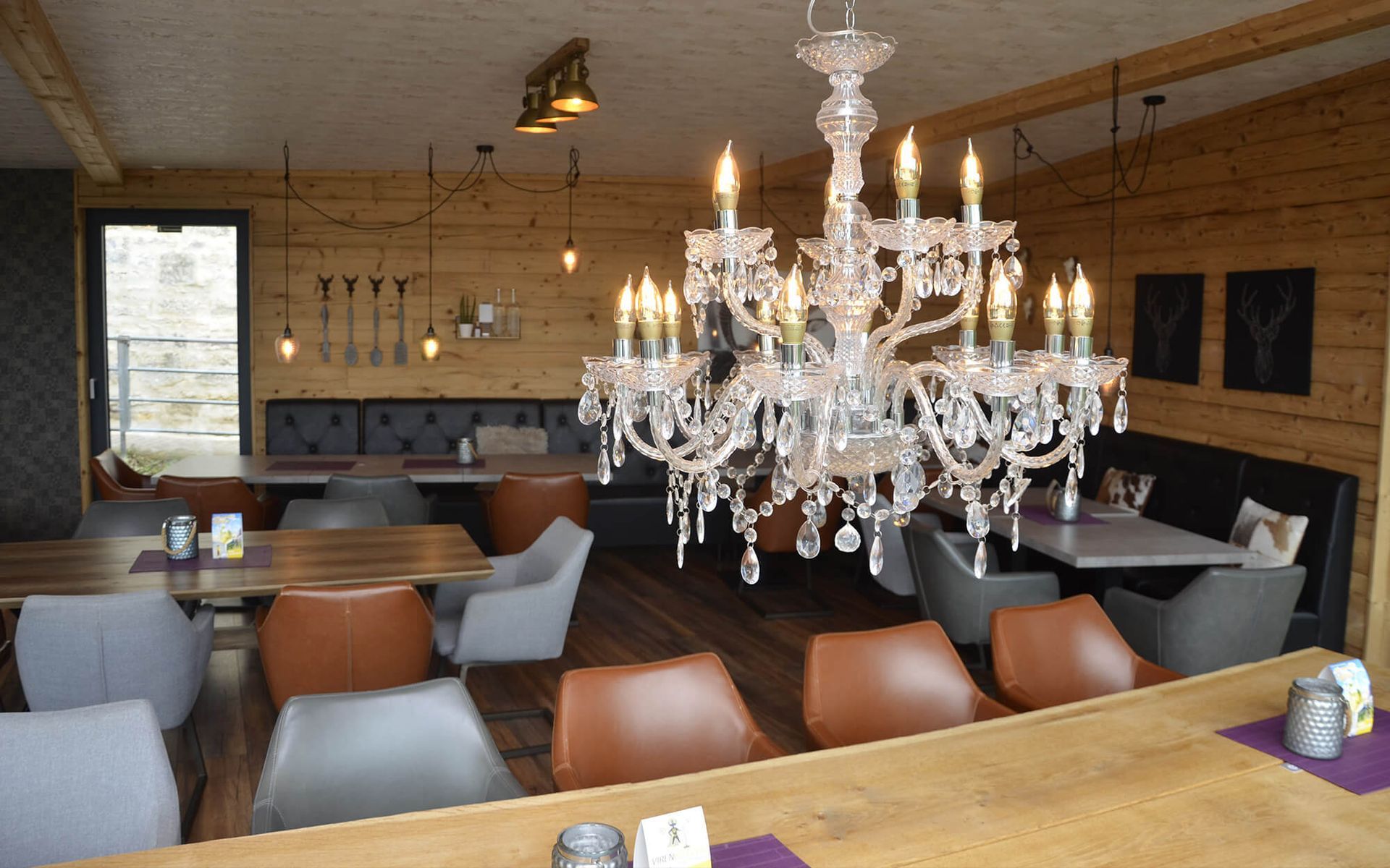 Ein Restaurant mit Tischen und Stühlen und einem Kronleuchter, der von der Decke hängt.