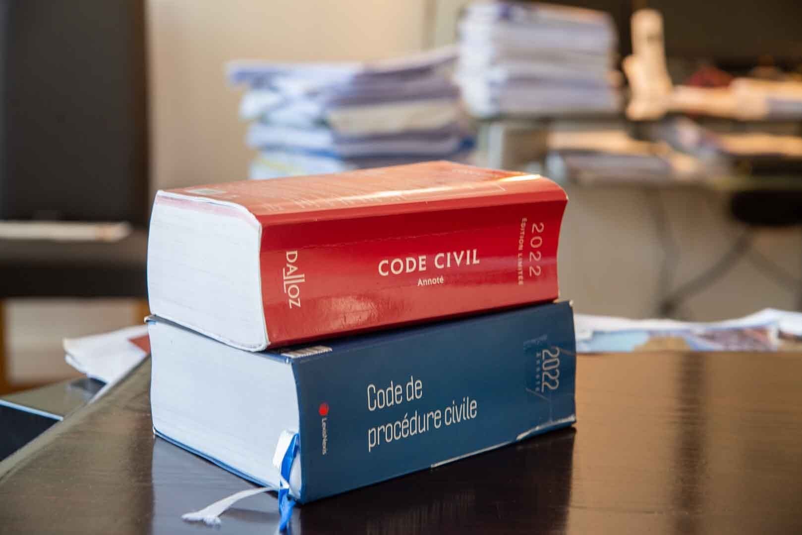 Livre rouge du Code Civil sur un livre bleu du Code de procédure civile