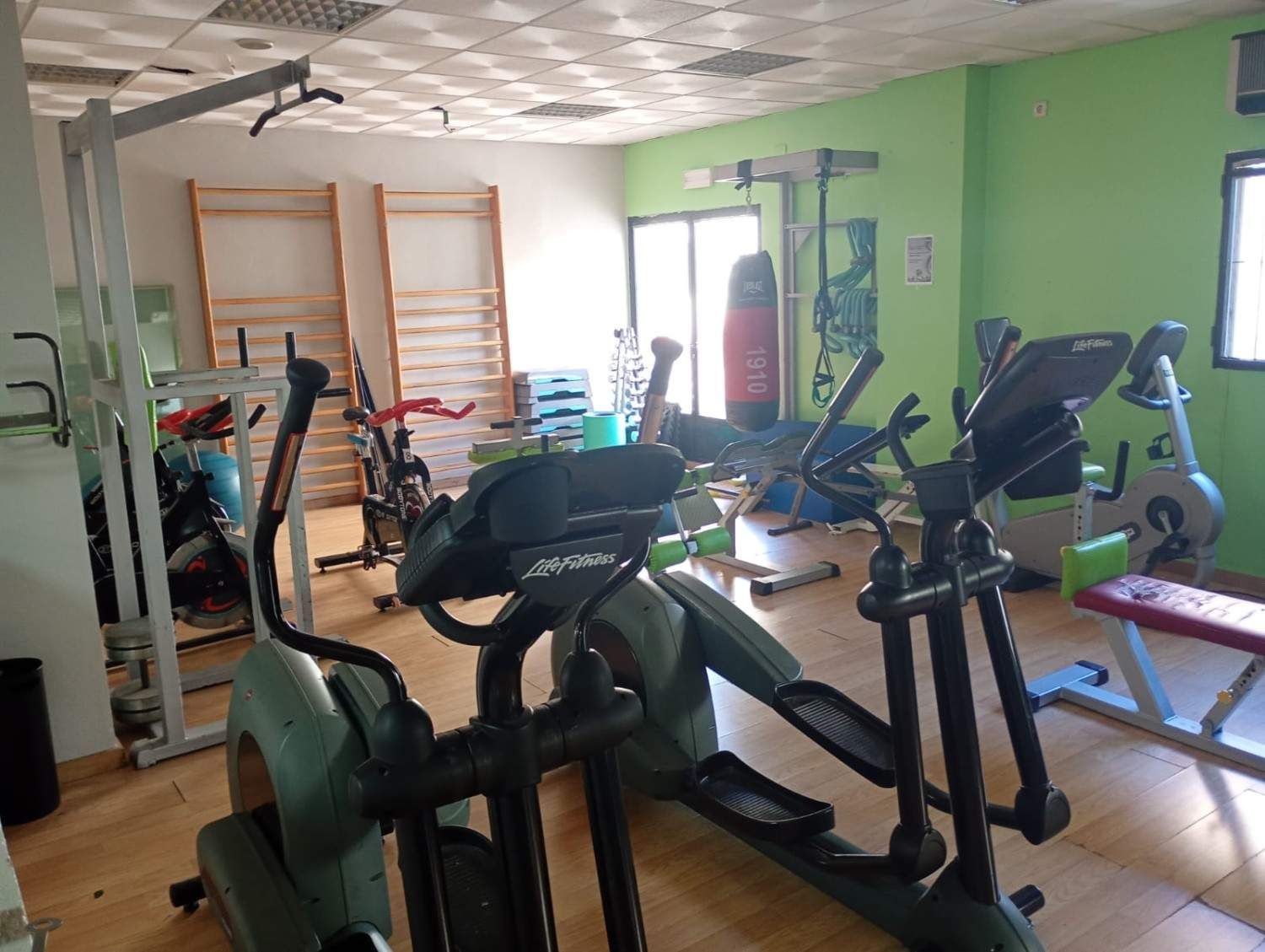 El interior de un gimnasio con máquinas elípticas, bicicletas estáticas