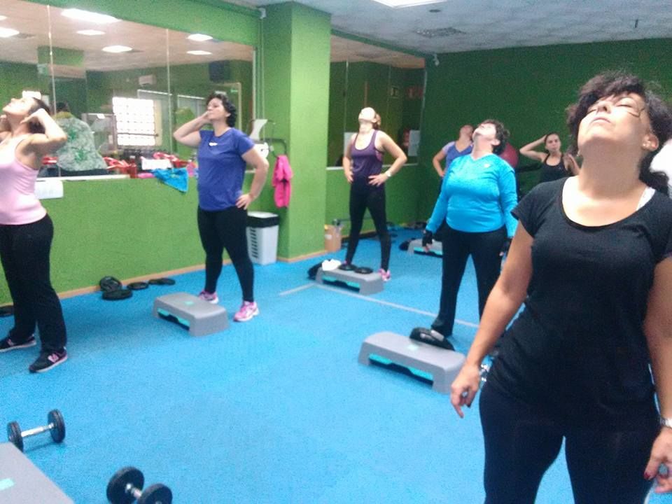Personas de pie en los escalones de un gimnasio con paredes verdes