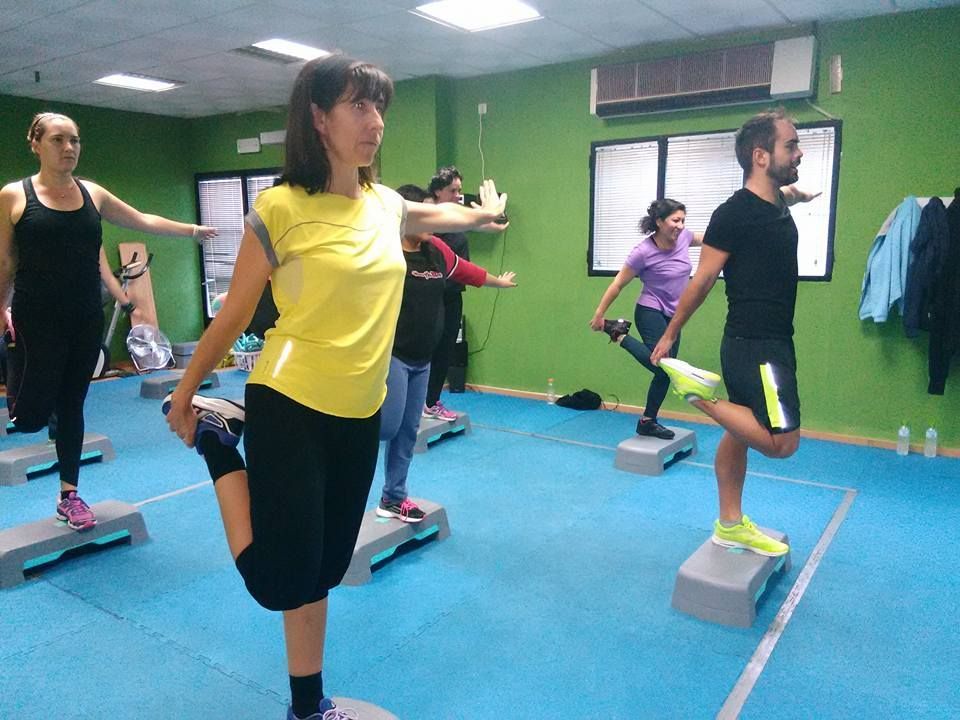 Un grupo de personas realizando un estiramiento de cuádriceps de pie