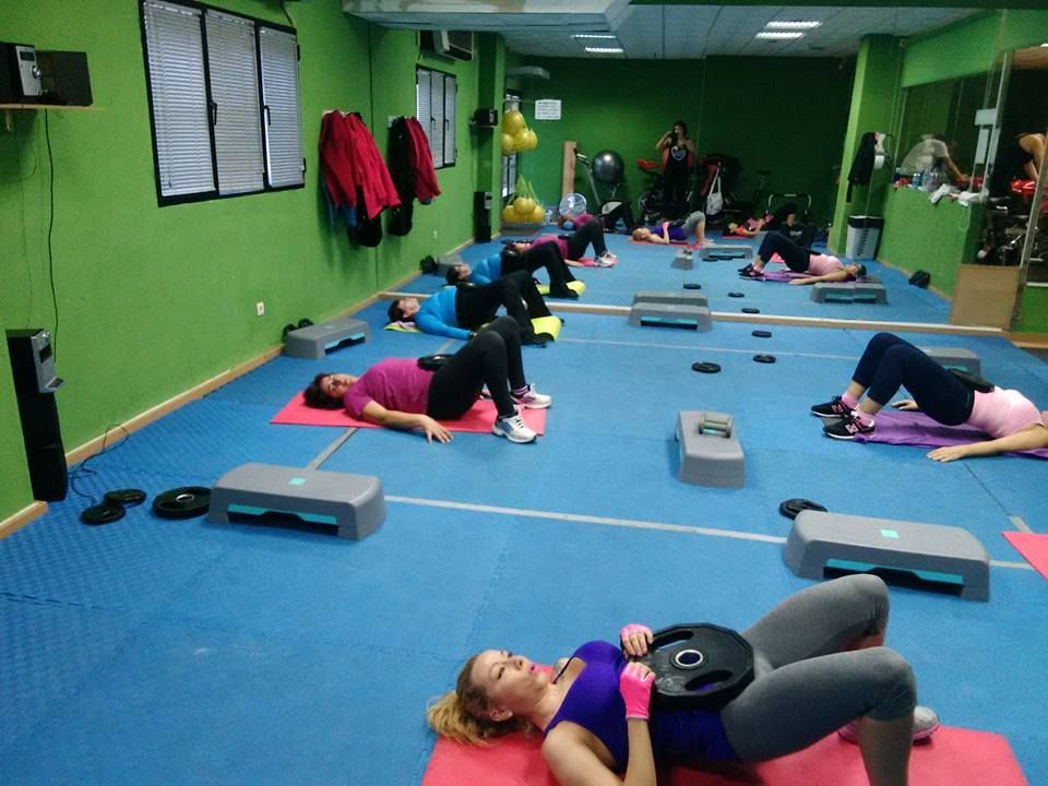 En un gimnasio, las personas realizan ejercicios de elevación de cadera sobre