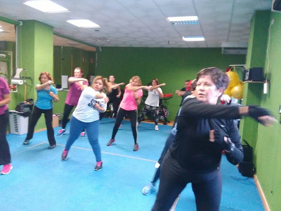 Un grupo de personas en un gimnasio haciendo ejercicio juntas