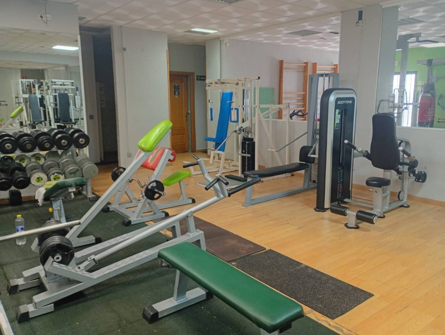 Un gimnasio bien iluminado con máquinas de ejercicio