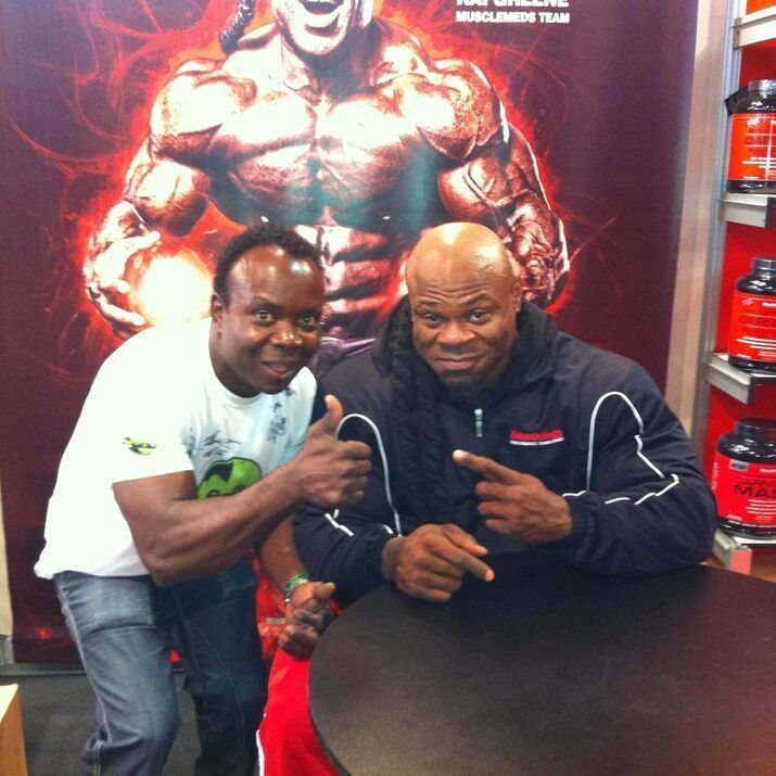 Dos hombres posan para una foto frente a una pancarta publicitaria