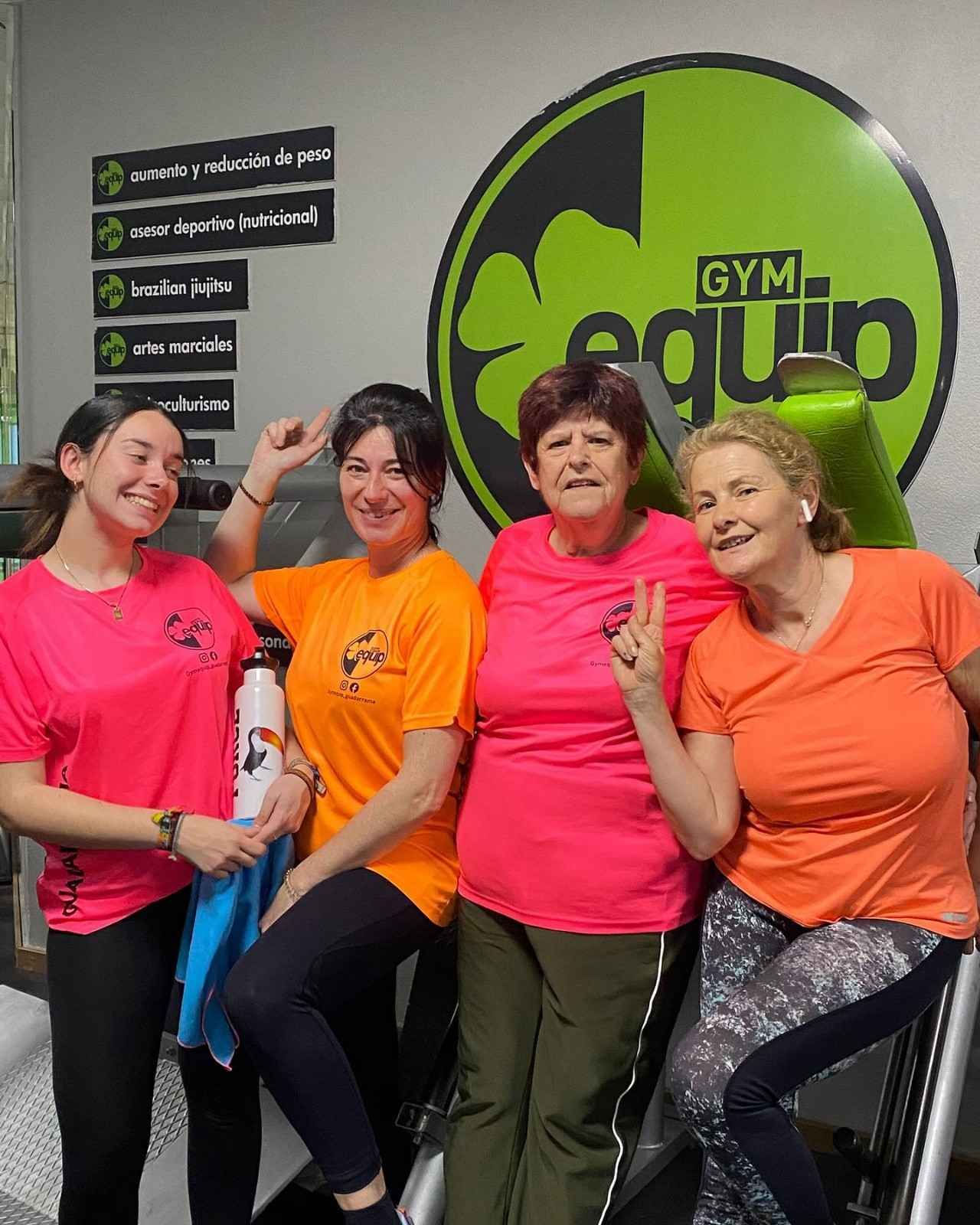 Cuatro personas sonriendo en un gimnasio