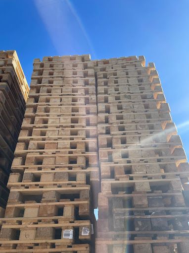 Un edificio alto construido con paletas de madera apiladas una sobre otra.