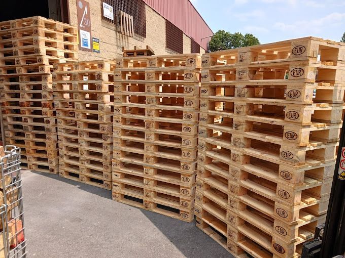 Un montón de paletas de madera están apiladas una encima de otra.