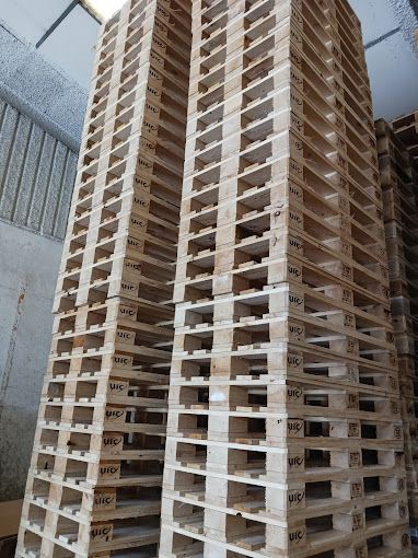 Una pila de paletas de madera apiladas una sobre otra en un almacén.