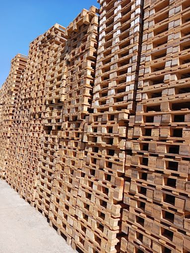 Una gran pila de paletas de madera apiladas una encima de otra.