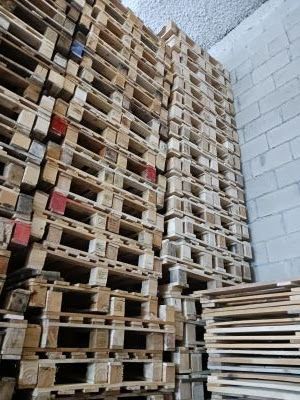 Un almacén lleno de montones de paletas de madera apiladas unas sobre otras.