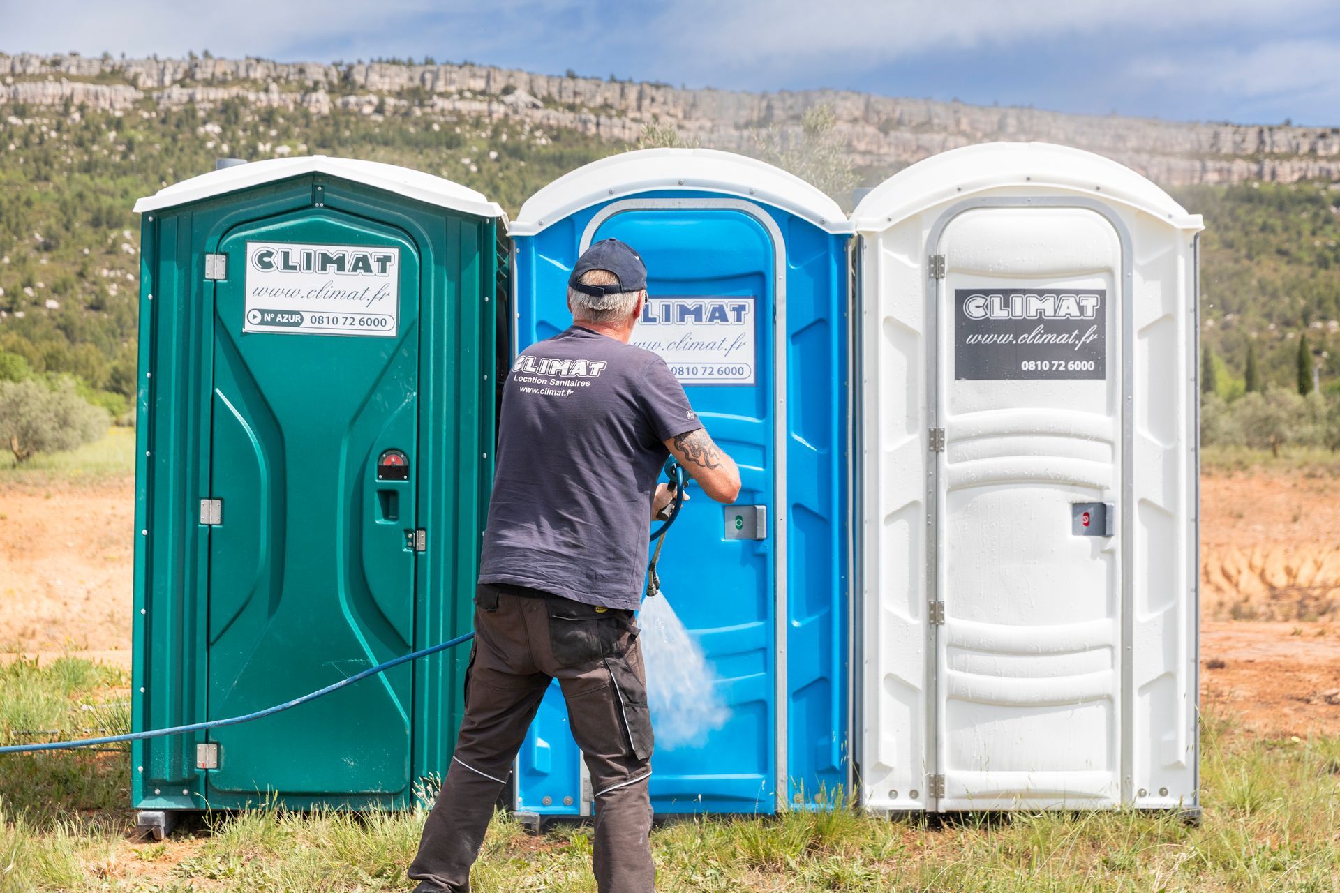 Employé qui nettoie des toilettes au jet à pression