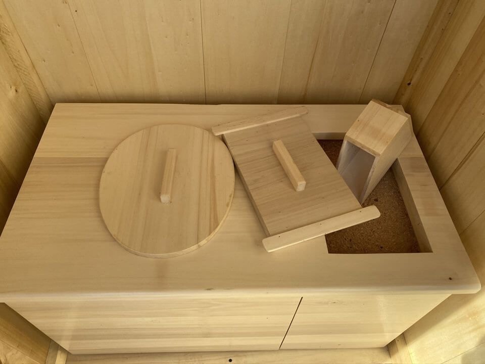 Toilettes sèches avec son réservoir de produits secs