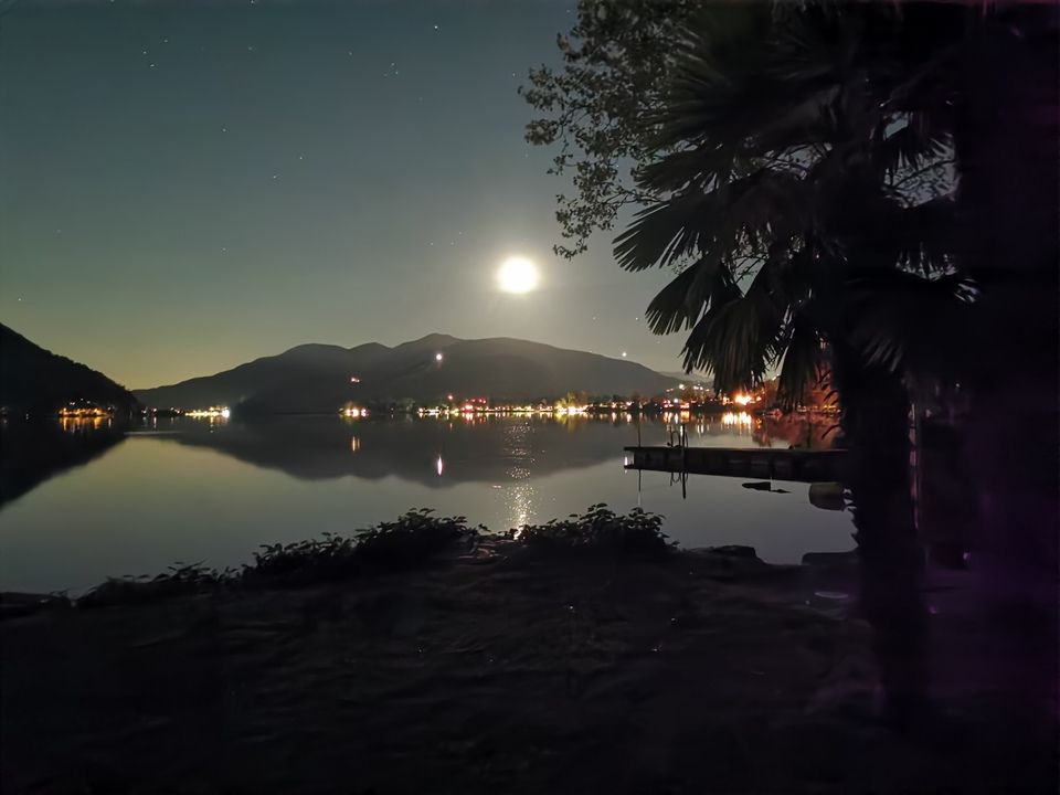 Di notte la luna piena splende su un lago