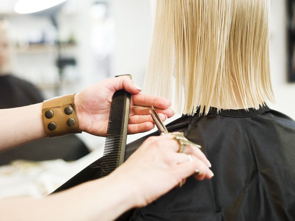 Una mujer se está cortando el pelo en una peluquería.