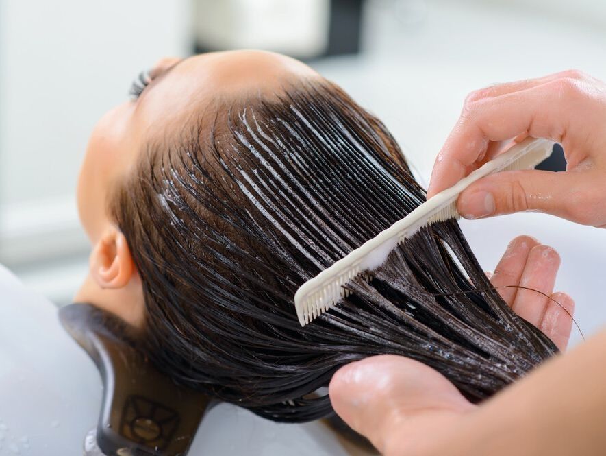 Una mujer se está peinando en una peluquería.