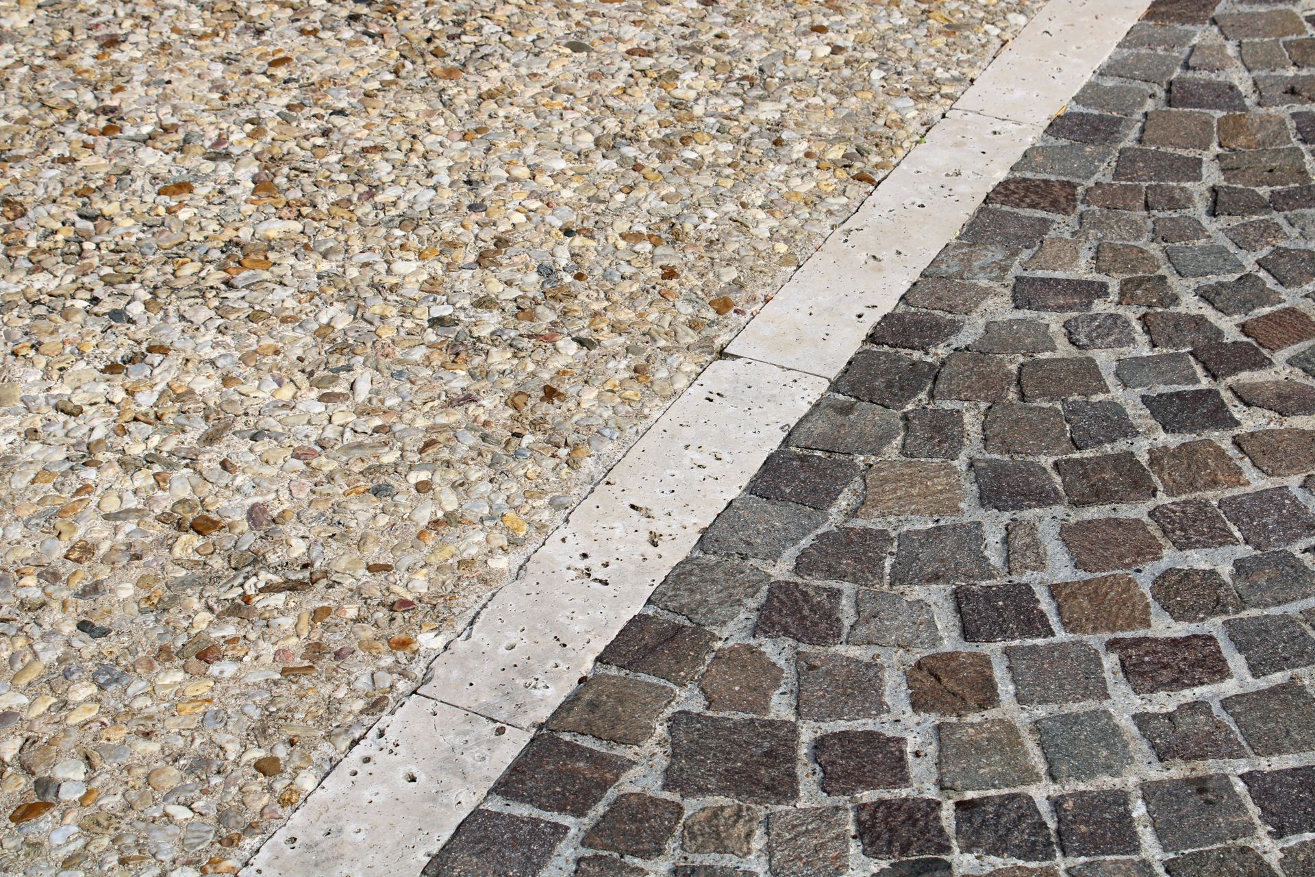 Revêtement de sol en béton désactivé et pavés divisé par une bordure en béton.