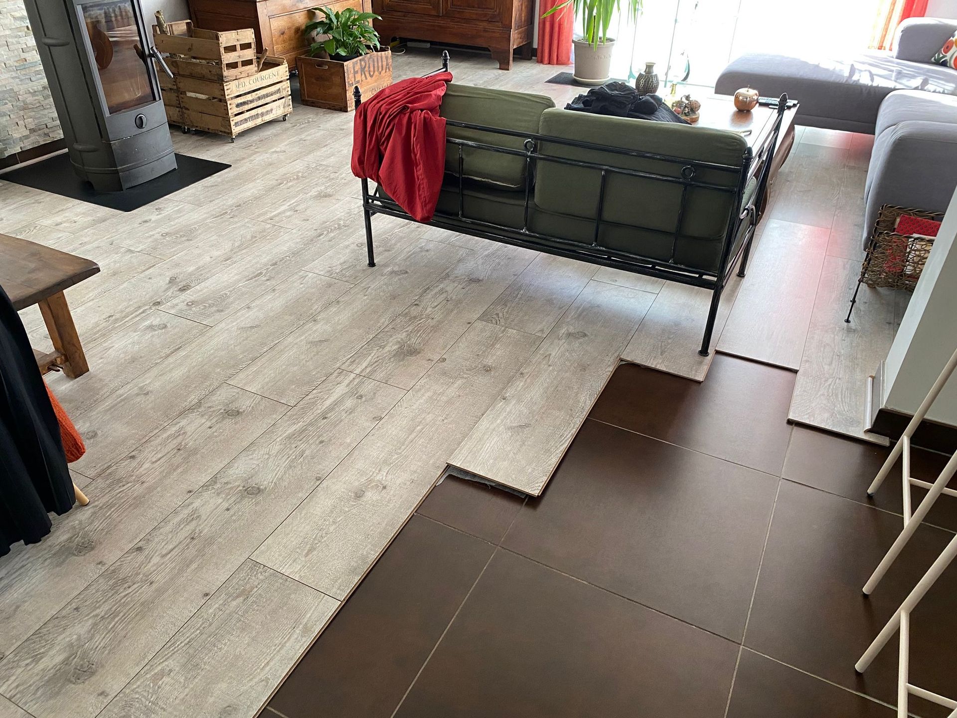 Salon dont le sol carrelé est en partie recouvert d'un parquet flottant.