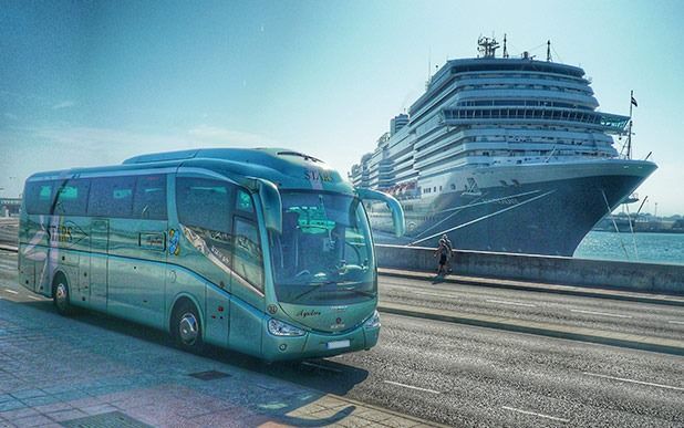 Un autobús circula por una calle al lado de un crucero.