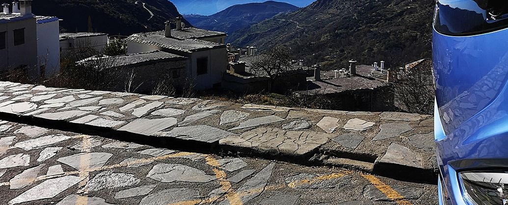 Una imagen de un paisaje con montañas al fondo y un objeto azul en primer plano.