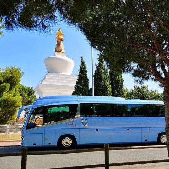 Un autobús azul con la letra m en el costado.