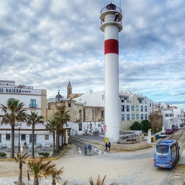 Un faro blanco y rojo está en el medio de una ciudad.