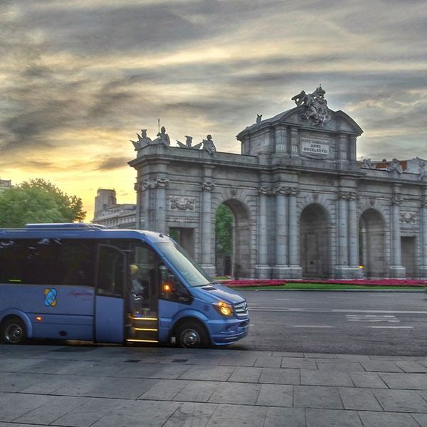 Una camioneta azul está estacionada frente a un gran edificio.