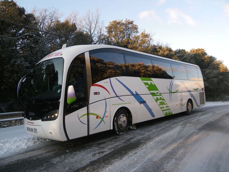 Un autobús blanco con la palabra Flecha en el costado