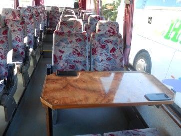 El interior de un autobús con una mesa y sillas.