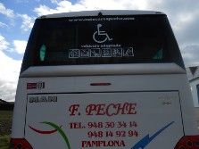 La parte trasera de un autobús blanco con una señal de discapacitado.