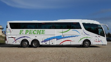 Un autobús blanco F. Peche está estacionado en un estacionamiento de grava.