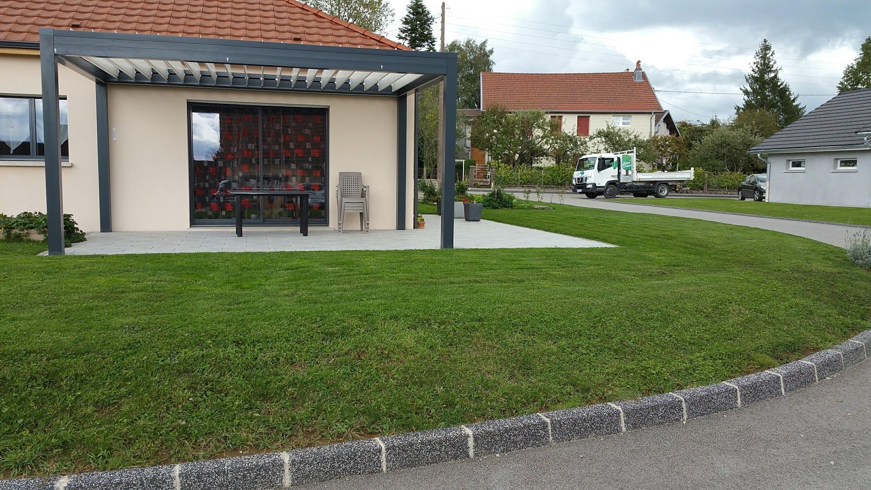 Photo d'une terrasse et d'un gazon vert réalisés par Les Jardins d'Adam